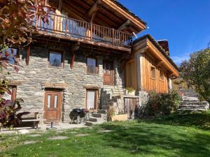 a large stone house with a balcony on top of it at Chalet des Laix in La Rosière