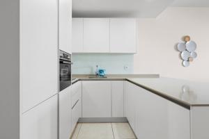 a white kitchen with white cabinets and a sink at Stunning Apt in Mijas by Costarentals - Ref 235 in Mijas Costa