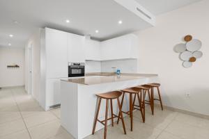 a kitchen with white walls and bar stools at Stunning Apt in Mijas by Costarentals - Ref 235 in Mijas Costa