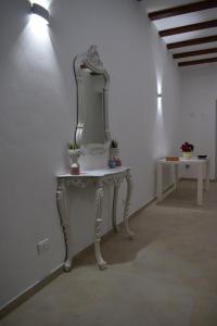 um toucador branco com um espelho na parede em La Dimora Di Garibaldi em Augusta