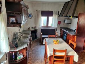 uma cozinha com uma mesa e uma cozinha com uma bancada em Ecorustics stay - Casa Estêvão em São Pedro do Sul