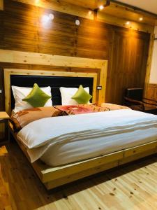 a bedroom with a large bed with wooden walls at Spiti Valley Hotel in Kaza