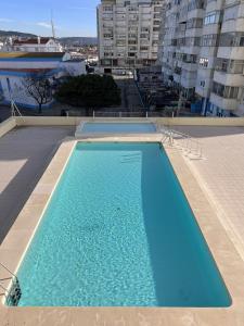 uma grande piscina azul no topo de um edifício em Casa Costa em Costa da Caparica