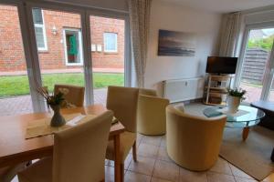 a living room with a table and chairs and a television at Strandkorb in Borkum