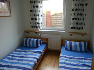 two beds in a room with a window at Strandkorb in Borkum