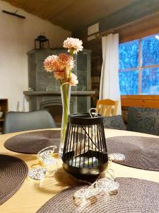 un jarrón de flores sentado sobre una mesa en Keloharju 18, en Syöte