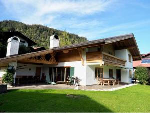 a house with a wooden roof and a yard at Chalet Chiemgau in Reit im Winkl