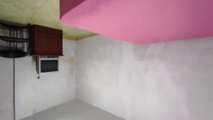 una camera con cucina e soffitto rosa di OYO 93299 Homestay Aqsa a Kendari