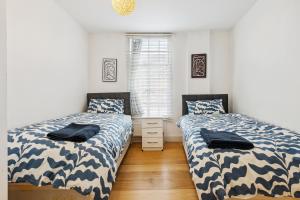 dos camas sentadas una al lado de la otra en un dormitorio en Cozy Central London Residence Stockwell, en Londres