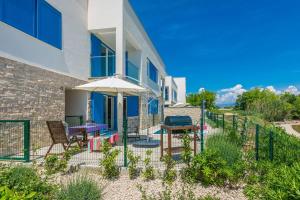 a house with a patio with a table and an umbrella at Villa Miri Jasmine in Privlaka