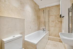 y baño con bañera, aseo y lavamanos. en Cozy Central London Residence Stockwell en Londres