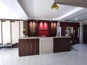 a lobby with a counter and a red wall at OYO 93278 Wisma Syariah Lahundape in Kendari