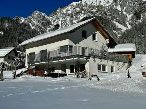 a large building in the snow in front of a mountain at apart belmonte in Wald am Arlberg