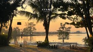 een uitzicht op een waterlichaam met bomen en stoelen bij Avare Seaside House Krabi in Ao Nam Mao