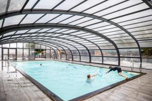 un groupe de personnes jouant dans une piscine dans l'établissement Huttopia Versailles, à Versailles