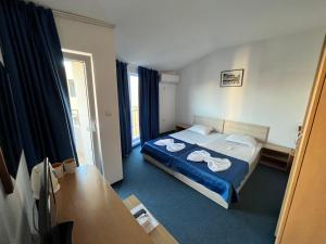 Una habitación de hotel con una cama con toallas. en Guest House Briz, en Nesebar
