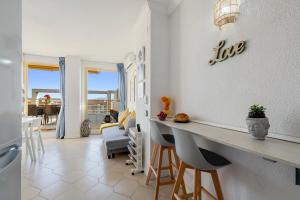a kitchen and living room with a counter and chairs at Salou apartment beach in Salou