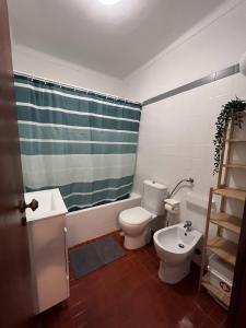 uma casa de banho com um WC, um lavatório e um chuveiro em Casa Costa em Costa da Caparica