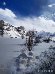 a snow covered field with mountains in the background at Spiti Valley Hotel in Kaza