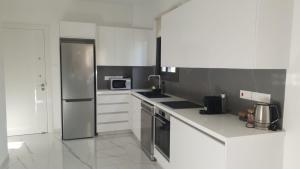 a kitchen with white cabinets and a stainless steel refrigerator at Hypnos Residence in Nicosia