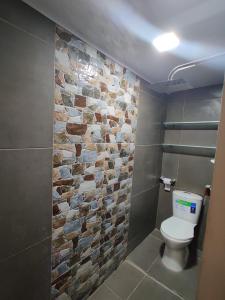 uma casa de banho com uma parede de pedra e um WC em Hotel - La Perla Del Caribe em Ríohacha