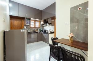 uma cozinha com uma mesa e um frigorífico em RZ Residency em Bangalore