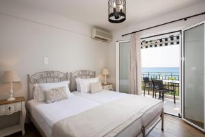 une chambre avec un lit et un balcon avec l'océan dans l'établissement Barefoot Contessa, à Lourdhata