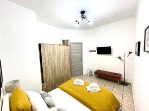 - une chambre avec un lit et une couverture jaune dans l'établissement La Badessa Home, à Naples