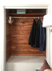 a closet with a wooden wall with clothes at Panther Mountain Lodge in Phoenicia