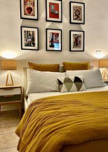 - une chambre avec un grand lit et des photos sur le mur dans l'établissement La Badessa Home, à Naples