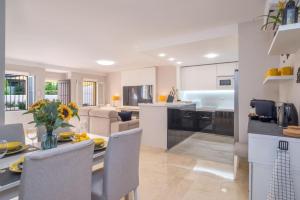 een keuken en een woonkamer met een tafel en stoelen bij Luxury DelMare Marbella Pool Family Only in Marbella