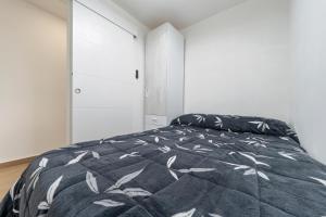 een slaapkamer met een bed met een zwart-witte deken bij Apartamento junto al mar en salou in Salou