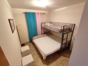 ein kleines Zimmer mit einem Etagenbett in einem Zimmer in der Unterkunft Villapolonia, casa 8 pax. piscina y aire ac. in Benicàssim