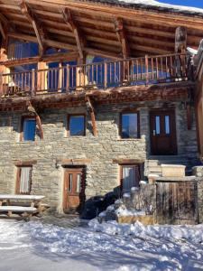 a log cabin in the snow with a deck at Chalet des Laix in La Rosière