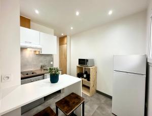 a kitchen with a white counter and a white refrigerator at LA CITADINE - Parking - Calme in Mont-de-Marsan