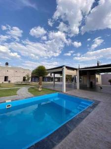 a large blue swimming pool in front of a building at Quinta del Eden, 9PX, Pool, BBQ, Pet Friendly in Matehuala