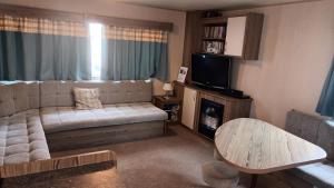 a living room with a couch and a table at 6 dunster court haven park doniford bay in Watchet
