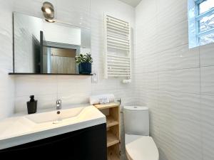 a white bathroom with a sink and a toilet at LA CITADINE - Parking - Calme in Mont-de-Marsan