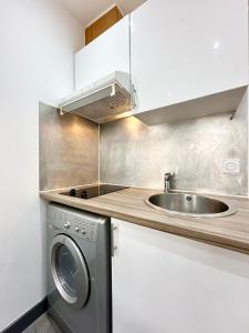 a kitchen with a sink and a washing machine at LA CITADINE - Parking - Calme in Mont-de-Marsan