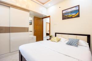 um quarto com uma grande cama branca e 2 almofadas em RZ Residency em Bangalore