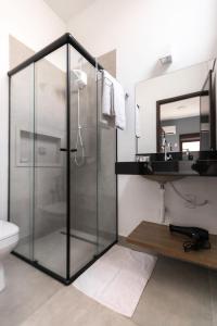 a bathroom with a glass shower and a sink at Vila Harmonia Brotas in Brotas