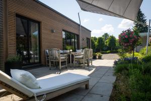 a patio with a table and chairs and an umbrella at Deine Genuss-Auszeit in Asendorf