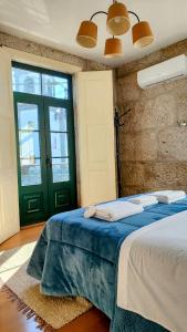 a bedroom with a bed and a green door at Donna Nega Alojamento Local in Caminha