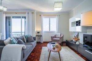 a living room with a couch and a tv at Sea View in Câmara de Lobos