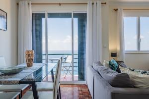 a living room with a glass table and a view of the ocean at Sea View in Câmara de Lobos