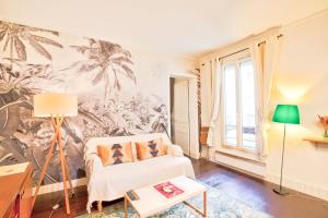a living room with a couch and a palm tree mural at French Romanticism in Paris