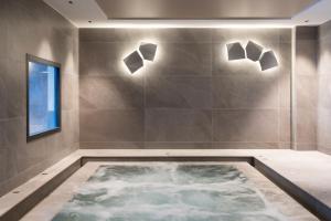 a bath tub in a bathroom with lights on the wall at Résidence Manaka in Aime La Plagne