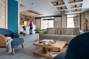 a living room with a couch and chairs and a table at Résidence Manaka in Aime-La Plagne