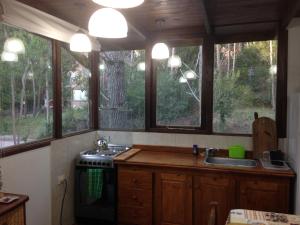 a kitchen with windows and a stove and a sink at Complejo Valhalla 6 in Mar Azul +7 photos