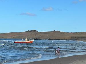 een paar mensen die op het strand lopen met een boot bij Pancho Villa in Barra de Valizas +14 foto's
